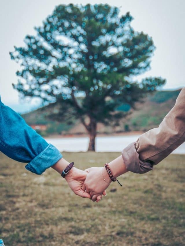 two persons holding hands