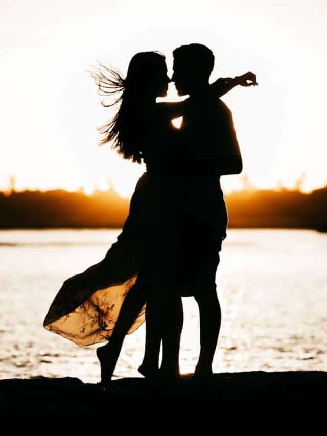 silhouette of woman standing on beach during sunset