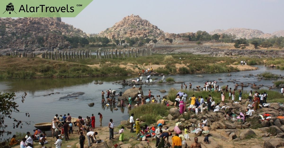 10 Romantic & Affordable Weekend Getaways for Couples 9 A group of people standing by a river with water and rocks in Hampi - Affordable Weekend Getaways for Couples.