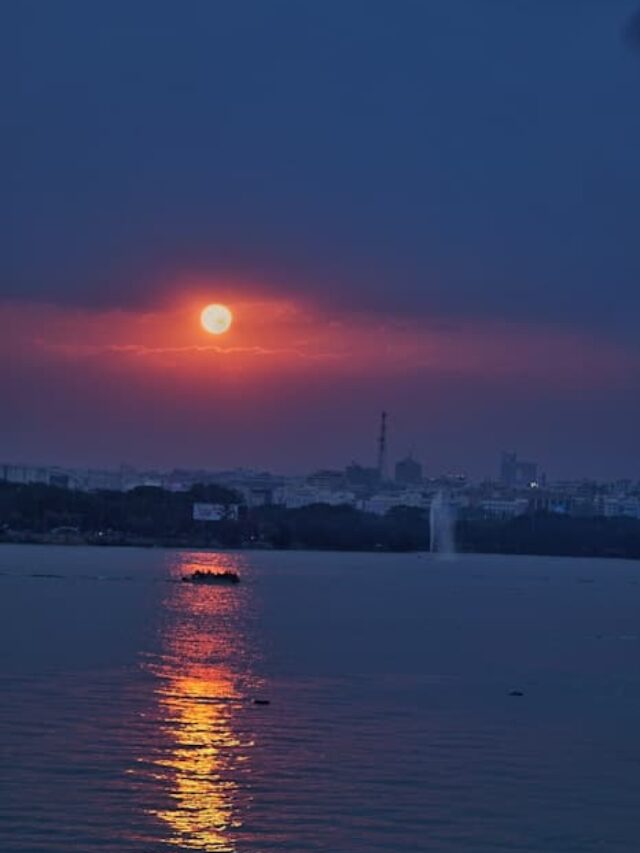 body of water near city during sunset